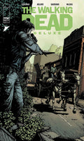 Comic book cover of 'The Walking Dead Deluxe' with a character holding a weapon and a horse-drawn carriage in the background.